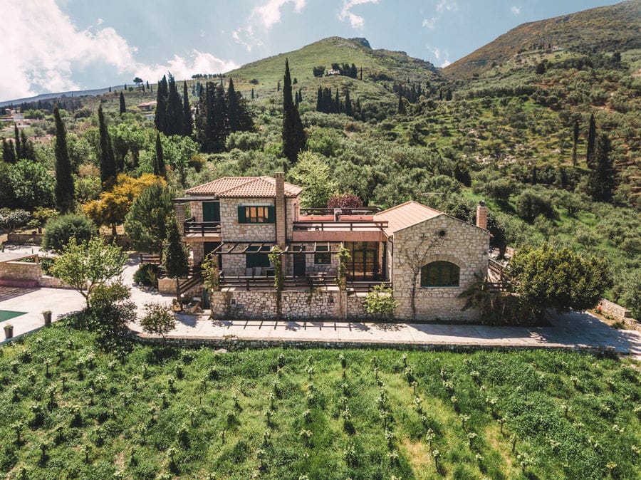 Klima Grampsa winery as a medieval building surrounded by vineyards and trees and mountains